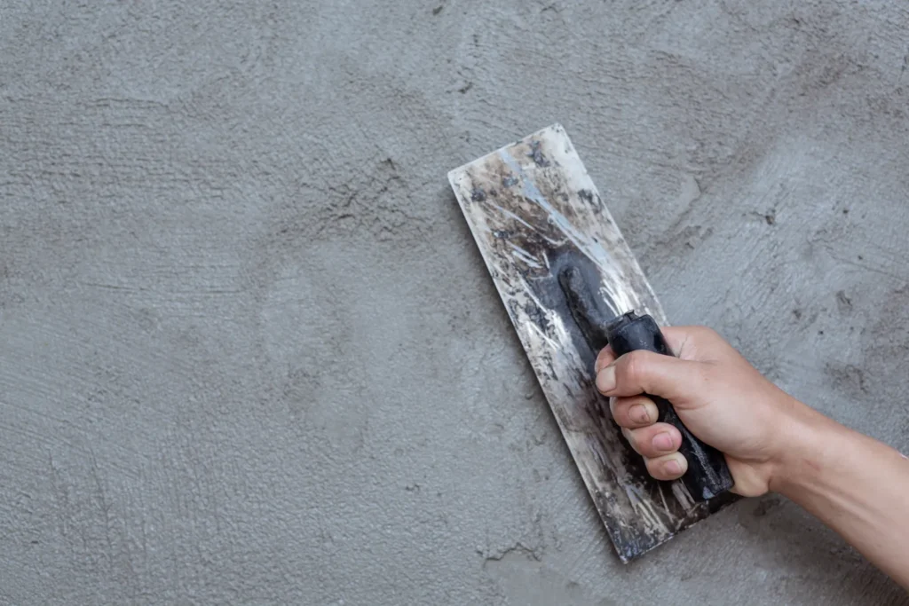 Aplicación de estuco con llana para preparar una pared antes de pintar